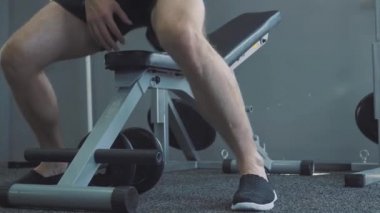 Halter salonunda - kas eğitim. Adam spor salonunda halter kaldırıyor. Haddelenmiş koca adam trenler dumbbells ile. Spor salonunda antrenör. Yaşam tarzı.