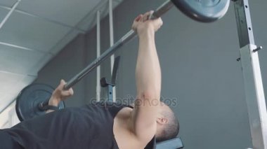 Halter salonunda - kas eğitim. Adam spor salonunda halter kaldırıyor. Haddelenmiş koca adam trenler dumbbells ile. Spor salonunda antrenör. Yaşam tarzı.