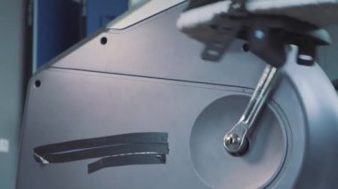 Genç çekici adam spor salonunda egzersiz bisikleti Bisiklete binme