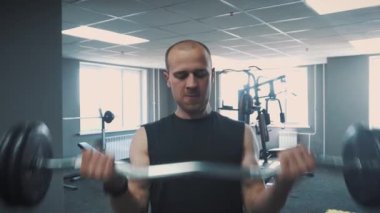 Halter salonunda - kas eğitim. Adam spor salonunda halter kaldırıyor. Haddelenmiş koca adam trenler dumbbells ile. Spor salonunda antrenör. Yaşam tarzı.