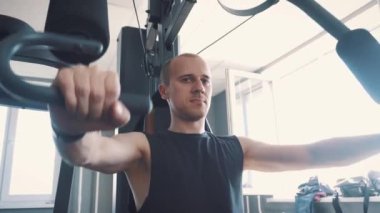 Genç kas eğitim kürek makine Fitness salonunda sert adam