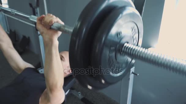 Halteres no ginásio - treinamento muscular. O homem levanta halteres no ginásio. O homem grande rolado treina com halteres. O treinador no ginásio. Estilo de vida . — Vídeo de Stock