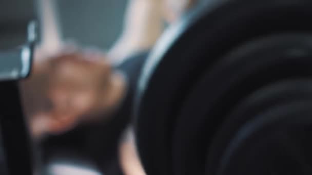 Haltères dans la salle de gym - entraînement musculaire. L'homme soulève des haltères dans la salle de gym. Les grands trains roulés avec des haltères. L'entraîneur dans la salle de gym. Mode de vie . — Video