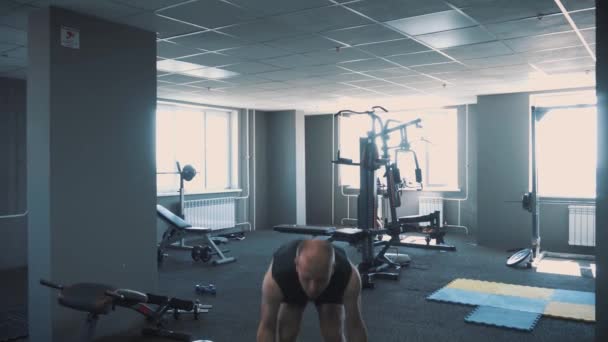 Halteres no ginásio - treinamento muscular. O homem levanta halteres no ginásio. O homem grande rolado treina com halteres. O treinador no ginásio. Estilo de vida . — Vídeo de Stock