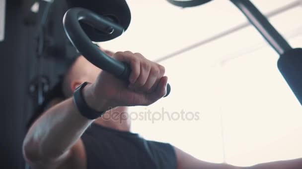 Giovane uomo muscolare formazione difficile su voga macchina in palestra — Video Stock