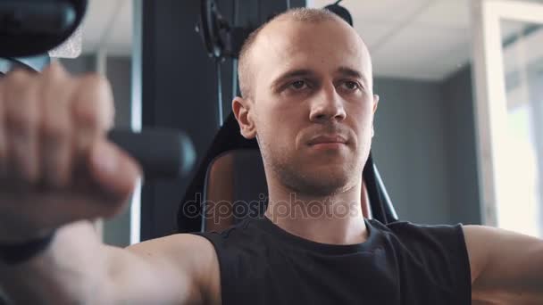 Jeune homme musclé s'entraînant dur sur la machine à ramer dans le studio de fitness — Video