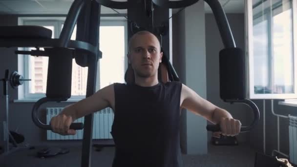 Ung muskulös Man utbildning hårt på roddmaskin i fitnesstudio — Stockvideo