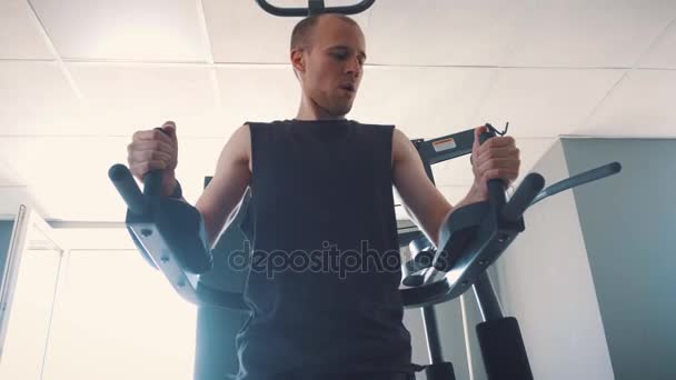 若い筋肉男ローイング マシン フィットネス スタジオでのハード トレーニング — ストック動画