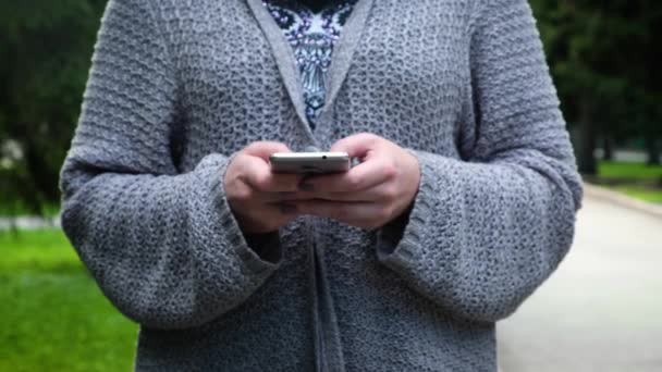 Vrouwelijke handen Closeup gebruik een Smartphone, Thumbing door middel van de informatie op het scherm van de Aanraking. het scherm van de telefoon reflecteert het zonlicht — Stockvideo