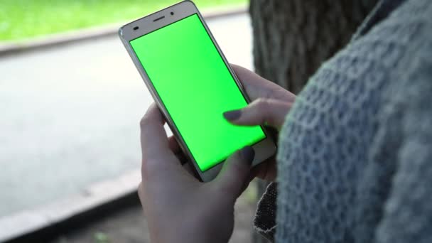 Mladá dívka je držení Smartphone s Green Screen na večerní čas. Ležérní životní styl. — Stock video
