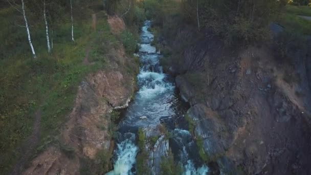 Vista aérea de la cascada. Hermosa cascada turística pequeña. Un pequeño lago en el que cae una cascada . — Vídeos de Stock