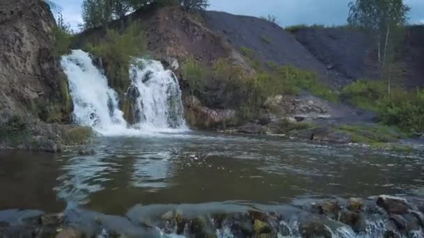 Flygfoto över vattenfallet. Vackra små turist vattenfall. En liten sjö som faller ett vattenfall. — Stockvideo