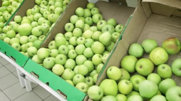 Szupermarket lány választja ki a zöld alma. Női kézi kiválasztása, és a zöld alma a szupermarketben vásárol. Egy nagy rakás zöld alma dobozok — Stock videók