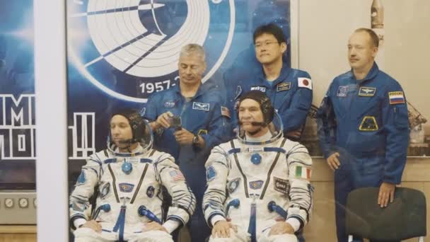 Μπαϊκονούρ, του Καζακστάν - Jule 28: Τρεις ζουν πραγματικά κοσμοναύτες πηγαίνετε για τον πύραυλο, να πω αντίο σε ένα πλήθος ανθρώπων, κουνήστε τα χέρια τους. Ντυμένος με μια διαστημική στολή. Έναρξη από το διαστημικό πύραυλο Σογιούζ Fg Ms-05. — Αρχείο Βίντεο