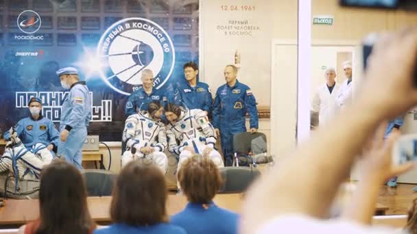 Kosmodromu, Kazachstán - Jule 28: Tři live skutečnou kosmonauti jít k raketě, rozloučit do davu lidí, mávají rukama. Na sobě skafandr. Spuštění kosmická raketa Sojuz Fg Ms-05. — Stock video