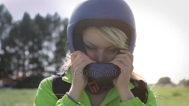 Portrait of a beautiful paraglider girl, blonde with blue eyes. He takes off his helmet. Indigo children. — Stock Video