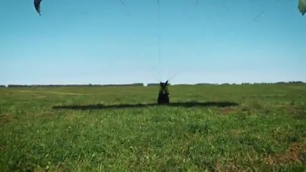 Gleitschirmfliegerin. Gleitschirm steht bereit, um über einen grünen Hügel abzuheben. — Stockvideo