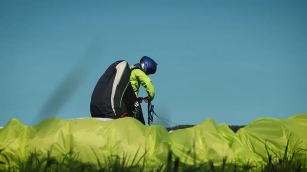 Fille de parapente. Parapente prêt à décoller sur une colline verdoyante . — Video