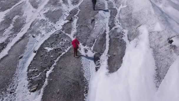 Aerial: Un uomo e una donna scalano il ghiacciaio su un'alta montagna in Alaska. Gli escursionisti professionisti sono impegnati in escursioni — Video Stock