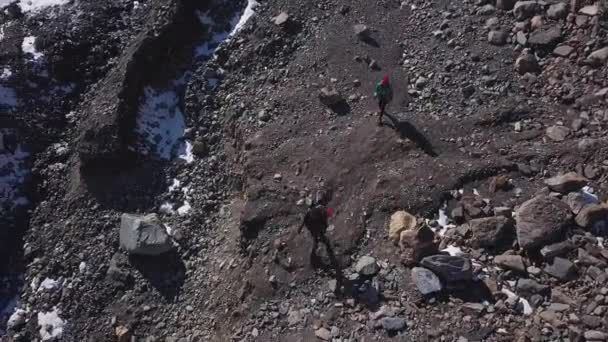 Antenne: Een man en een vrouw zijn klimmen op de gletsjer naar een hoge berg in Alaska. Professionele wandelaars zijn betrokken bij wandelen — Stockvideo