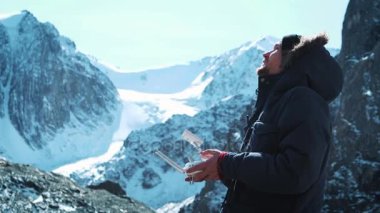 Uçağı uzaktan denetleme. El ve bir casus uçak pilot operatörü uzaktan görünümü. Bir gezgin karlı dağlarda fotoğraf çeker ve bölge inceliyor.