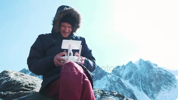 Drone op afstand besturen. Hand en de weergave Extern van de exploitant van een drone-piloot. Een reiziger in de besneeuwde bergen foto's neemt en onderzoekt het grondgebied. — Stockvideo