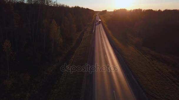 Légi: az autót a konténer lovagolni az út a naplemente. Kamion az autópályán túrák. — Stock videók