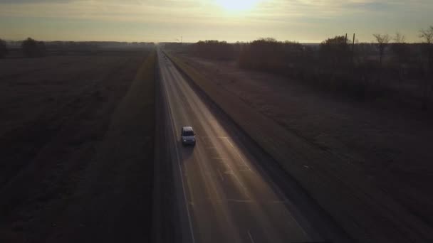 Anteni: güneşe doğru sürüş dağıtım kamyonları. gün batımını giden yolda konteyner ile araba sürmek. Otoyol kamyon sürmek. — Stok video