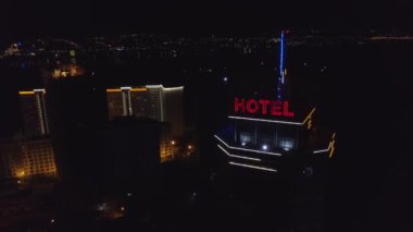 Anteni: Gece şehirde modern bir binanın çatı Neon kırmızı yazıt oteli. Rating arabalar yola gelecek. Bir gökdelenin çatı üzerinde kelime otel