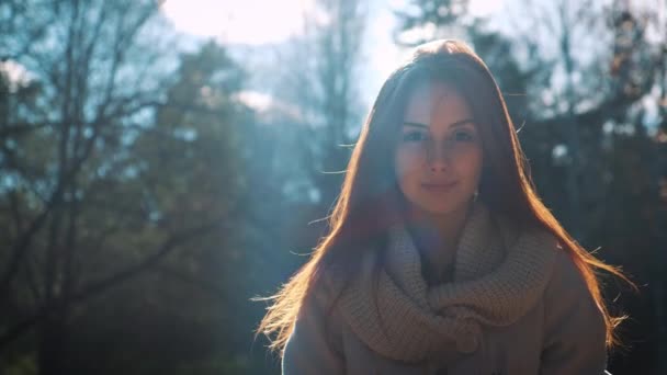 Menina ruiva elegante fica em uma floresta ou parque no outono . — Vídeo de Stock