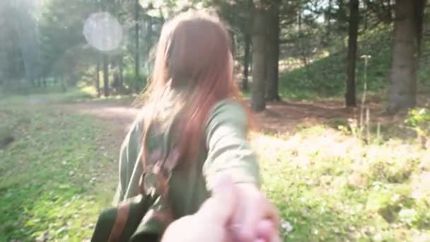 Sígueme a las aventuras. Joven hermosa pelirroja con una mochila. Sigue la aventura en el bosque. Toma la mano de un hombre o de un hombre — Vídeos de Stock