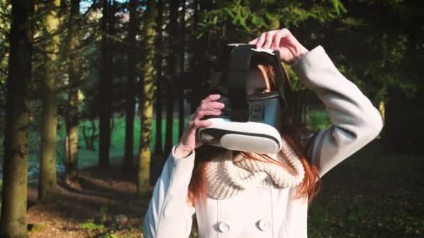 这个女孩在公园或树林里使用虚拟现实眼镜。玩游戏360度. — 图库视频影像