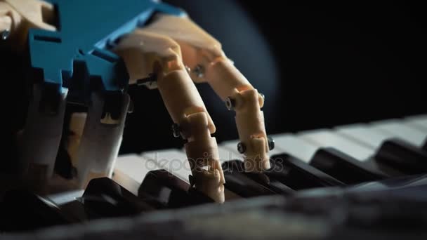 Чоловік-музикант піаніст з протезною рукою грає на піаніно. Він грає з двома руками, роботом і людською рукою. Робот створює музику та мистецтво — стокове відео
