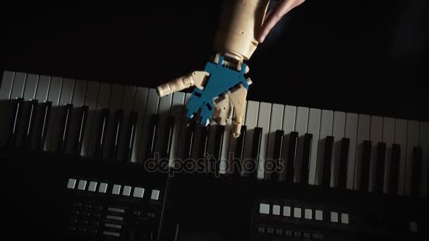 Robot plays a musical instrument. man musician pianist with a prosthetic hand playing the piano. He plays with two hands, a robot hand and a human hand. Robot creates music and art — Stock Video