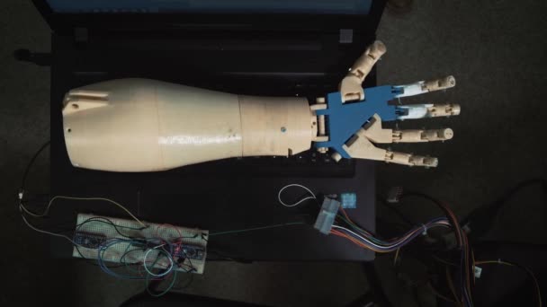 Moderne Robotertechnologien in der Wissenschaft. die androiden hand bewegt sich mit mechanischen fingern im testmodus. die Hand liegt auf dem Laptop, verbunden mit den Drähten. — Stockvideo