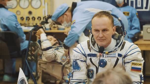 BAIKONUR, KAZAKHSTAN - JULHO 28: Três cosmonautas reais vivos vão ao foguete, se despedem de uma multidão de pessoas, acenam com as mãos. Vestida com um fato espacial. Lançamento do foguete espacial Soyuz FG MS-05 . — Vídeo de Stock