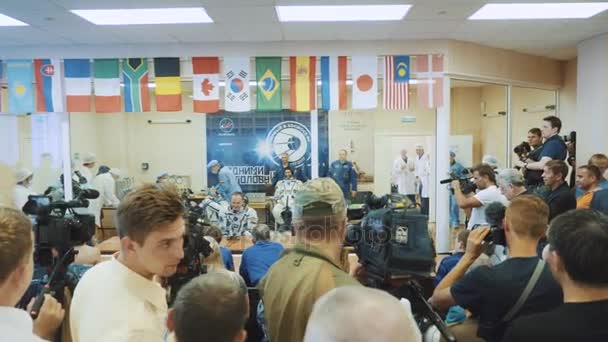 BAIKONUR, KAZAKHSTAN - JULE 28: Three live real cosmonauts go to the rocket, say goodbye to a crowd of people, wave their hands. Dressed in a space suit. Launch of the Soyuz FG MS-05 space rocket. — Stock Video