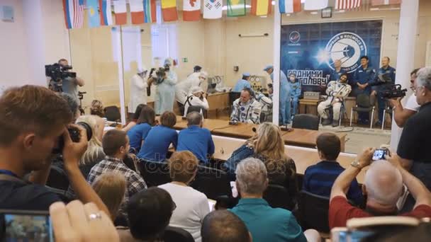 BAIKONUR, KAZAKHSTAN - 28 DE JULIO: Tres cosmonautas reales en vivo van al cohete, se despiden de una multitud de personas, saludan con las manos. Vestido con un traje espacial. Lanzamiento del cohete espacial Soyuz FG MS-05 . — Vídeo de stock