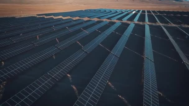 Letecký pohled na pouštní velké průmyslové solární energie farmu produkující koncentrované solární energie. Kolem hory a zapadne slunce při západu slunce. — Stock video