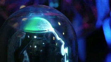 Yeşil soyut elektrik ışık bir cam şişeye. Bir plazma topu gibi. Adamın parmaklarını yıldırım dokunur. İletim elektrik enerjisi havada, elektrik kablosuz iletim