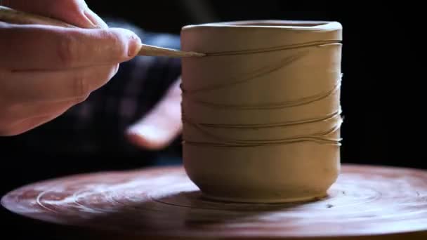 Gros plan des mains de travail de l'argile sur la roue des potiers. Potier façonne le produit d'argile avec des outils de poterie sur la roue des potiers, vue de dessus, tonique cinématique, usine artisanale authentique — Video