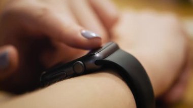 Çeşitli jestleri bir parmak ile bir akıllı izle giyilebilir aygıtı dokunmatik ekranda yapma. Kız kafede oturuyor, akıllı bir saati kullanır