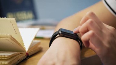 Çeşitli jestleri bir parmak ile bir akıllı izle giyilebilir aygıtı dokunmatik ekranda yapma. Kız kafede oturuyor, akıllı bir saati kullanır