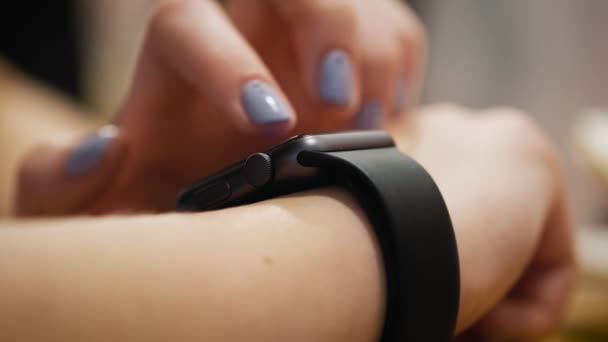 Různých gest prstem na dotykové obrazovce inteligentní watch nositelné zařízení. dívka sedí v kavárně, používá smart clock — Stock video