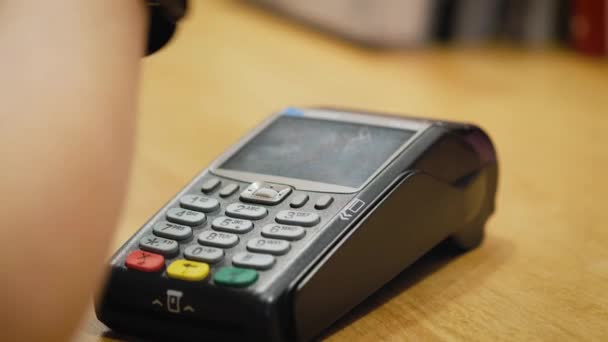 Cliente que paga con tecnología NFC por reloj inteligente sin contacto en la terminal en la cafetería moderna — Vídeo de stock