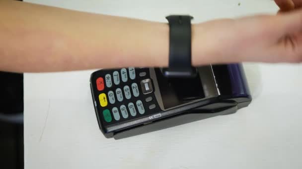 Il cliente che paga con la tecnologia NFC tramite smart watch senza contatto sul terminale in un moderno caffè — Video Stock
