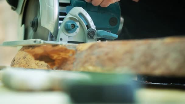 Corte de suelo de madera por sierra eléctrica. El carpintero sierra un tronco o tabla . — Vídeo de stock