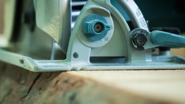 Corte de suelo de madera por sierra eléctrica. El carpintero sierra un tronco o tabla . — Vídeo de stock