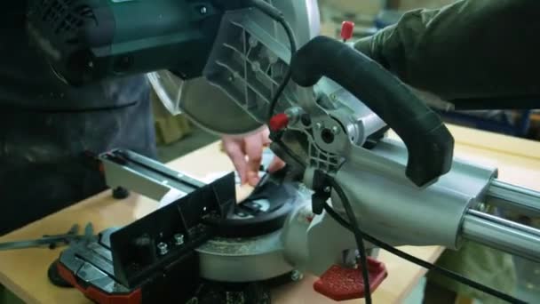 Egy ember Asztalos a fa segítségével egy speciális gép, egy stúdióban dolgozik. Az asztalos körfűrész gép használ — Stock videók
