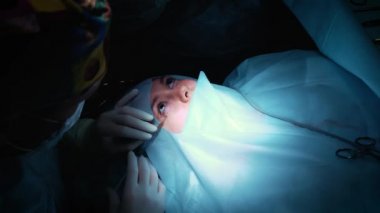 Cerrah bir operasyonu göze, yakın çekim. Gözleri ve göz düzeltme. Doktor Blefaroplasti yapar. Ameliyathane işlem. Neşter ve kelepçe yakın öğrenci çok